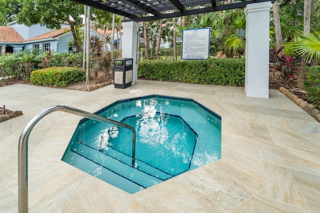 view of pool with a hot tub