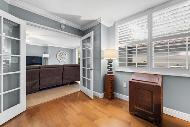 interior space featuring french doors, a textured ceiling, light hardwood / wood-style floors, and crown molding