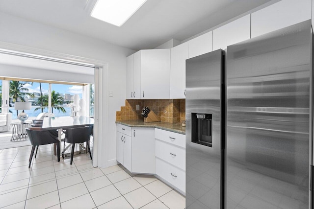 44 Cocoanut Row Unit 120B, Palm Beach, FL 33480 - kitchen featuring stainless steel fridge, decorative backsplash, white cabinets, and dark stone counters