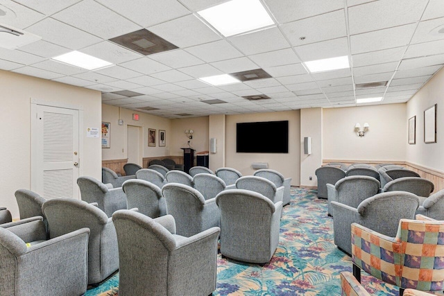 carpeted home theater room featuring a paneled ceiling