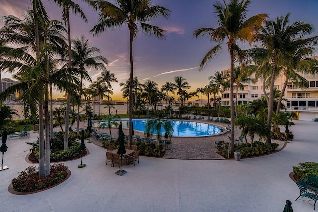 pool at dusk with a patio