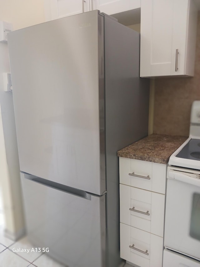 110 Northampton Unit F, West Palm Beach, FL 33417 - kitchen with freestanding refrigerator, dark stone countertops, white cabinets, and white range with electric cooktop