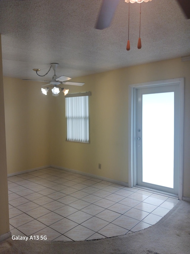 spare room featuring light carpet, a textured ceiling, and ceiling fan