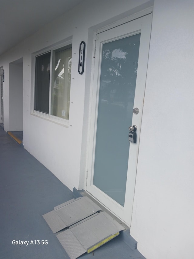 110 Northampton Unit F, West Palm Beach, FL 33417 - doorway to property featuring stucco siding