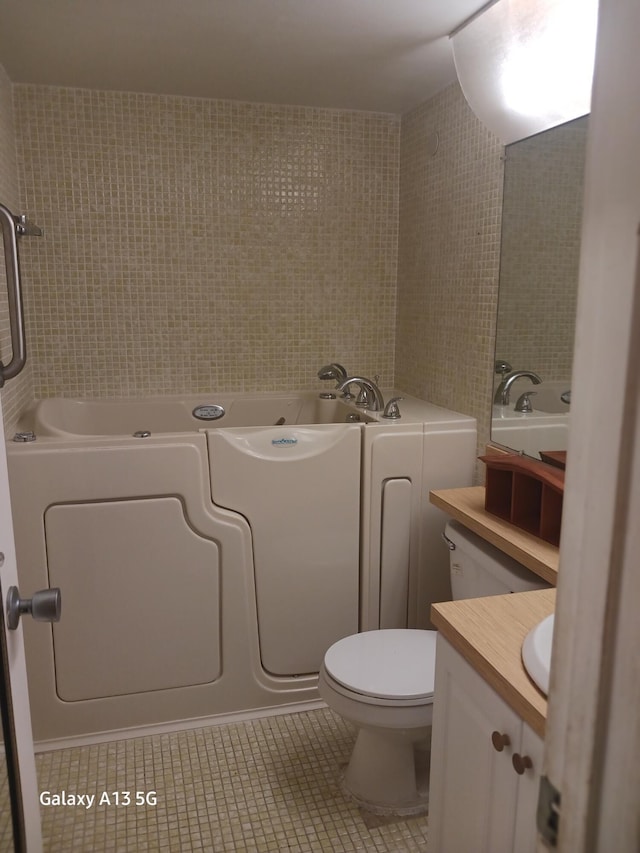 110 Northampton Unit F, West Palm Beach, FL 33417 - full bathroom featuring tile patterned flooring, vanity, toilet, tile walls, and a jetted tub