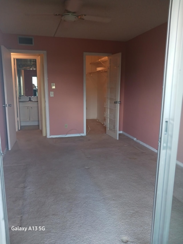 110 Northampton Unit F, West Palm Beach, FL 33417 - unfurnished bedroom featuring visible vents, a closet, baseboards, a spacious closet, and carpet
