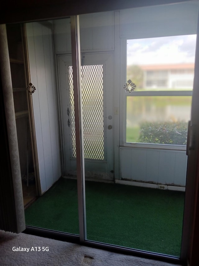 doorway to outside with carpet flooring