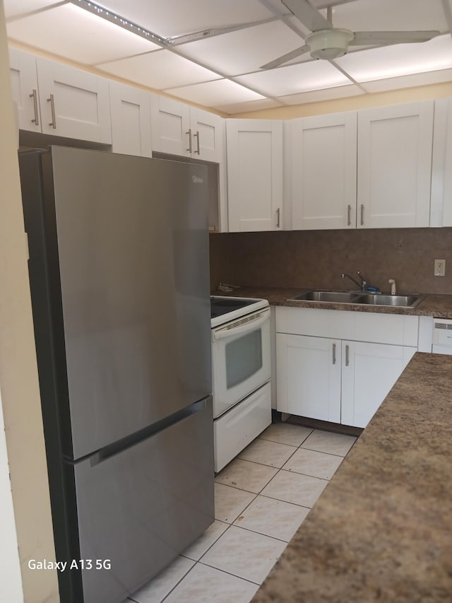 110 Northampton Unit F, West Palm Beach, FL 33417 - kitchen with freestanding refrigerator, white cabinetry, white electric stove, and a sink