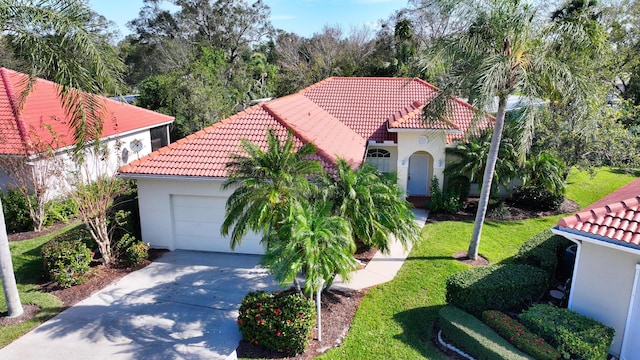 mediterranean / spanish home featuring a garage and a front yard