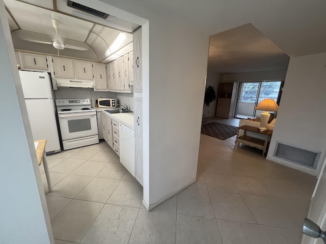 kitchen featuring white appliances, ceiling fan, sink, light tile patterned floors, and white cabinets