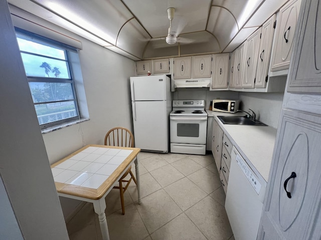 kitchen with white appliances, ceiling fan, sink, light tile patterned floors, and white cabinets