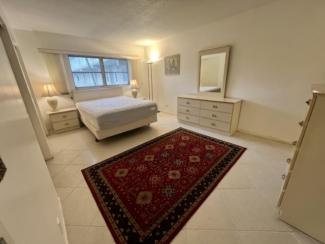 bedroom featuring light tile patterned floors and a textured ceiling