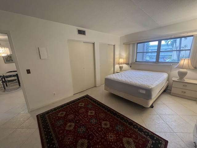 bedroom featuring multiple closets and light tile patterned flooring