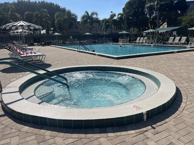 view of pool featuring a community hot tub and a patio area