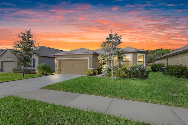 view of front of house with a garage, driveway, a front lawn, and stucco siding