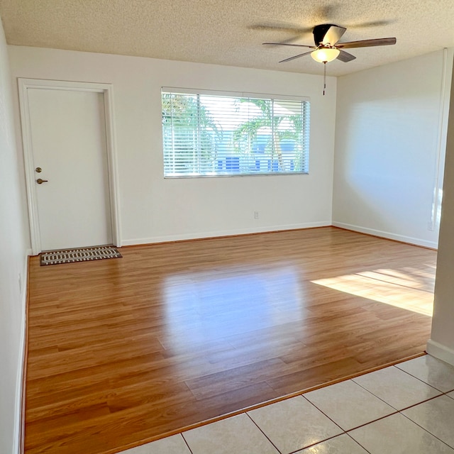 spare room with light hardwood / wood-style flooring, a textured ceiling, and ceiling fan