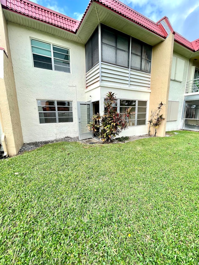 rear view of property featuring a yard