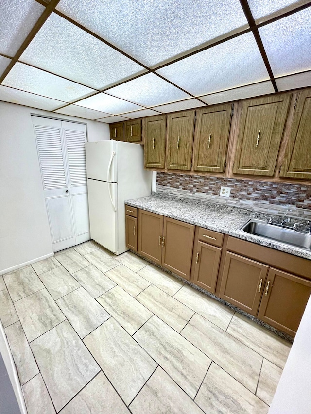 kitchen featuring sink, tasteful backsplash, and white refrigerator