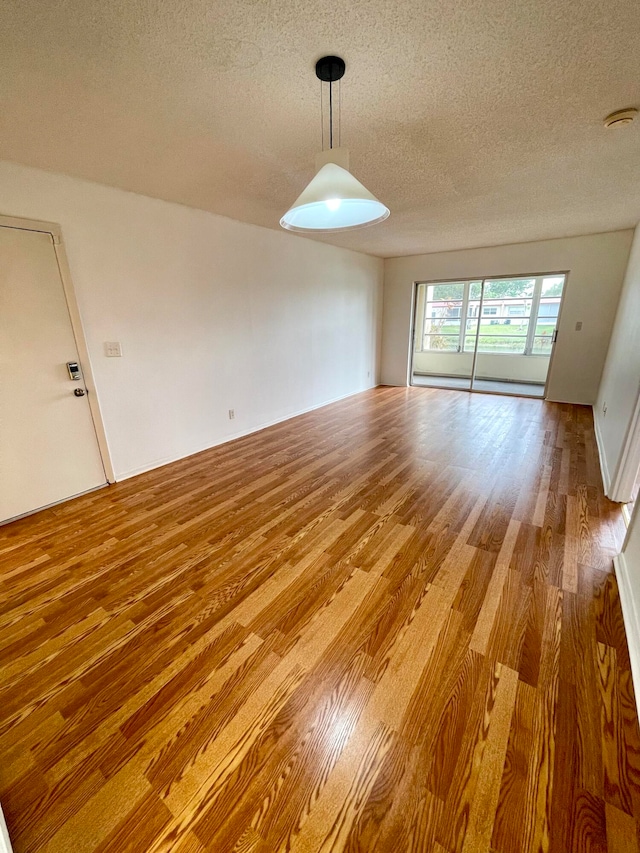 unfurnished dining area with a textured ceiling and hardwood / wood-style flooring