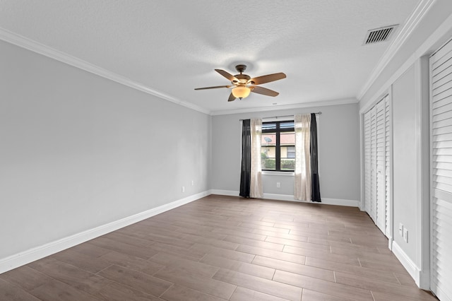 unfurnished room with ornamental molding, light hardwood / wood-style flooring, a textured ceiling, and ceiling fan