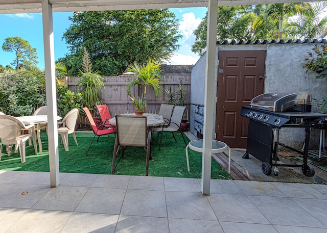 view of patio with a shed and a grill