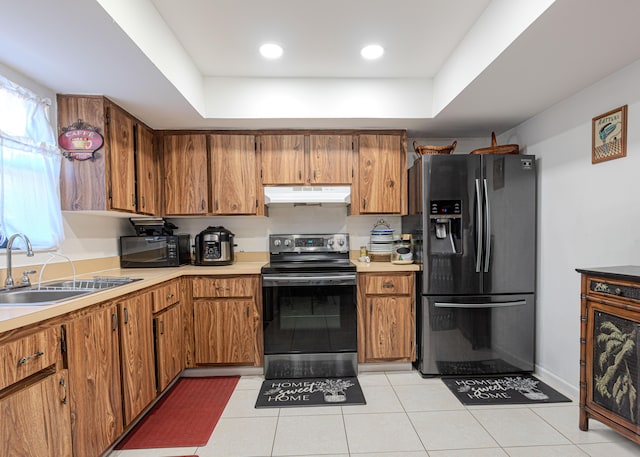 kitchen featuring electric range, sink, stainless steel fridge with ice dispenser, and a raised ceiling