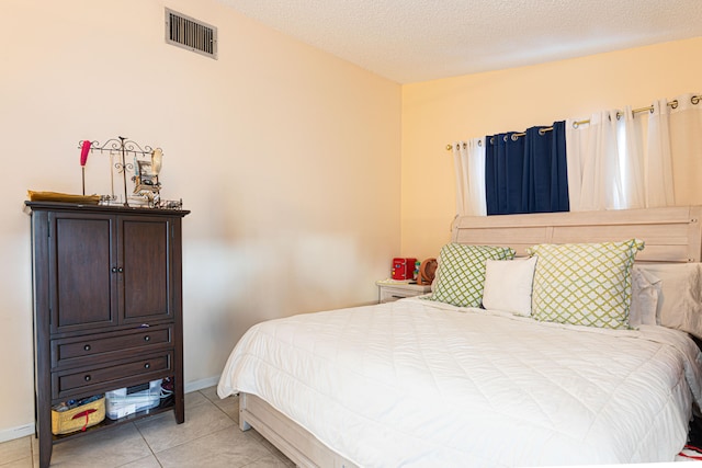 bedroom featuring a textured ceiling and light tile patterned floors