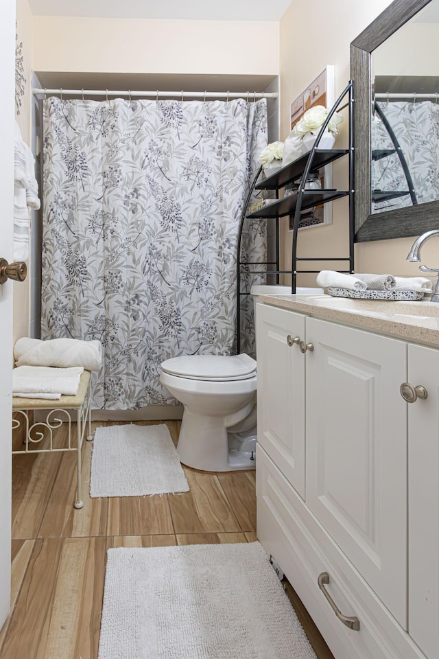 bathroom featuring vanity, hardwood / wood-style flooring, and toilet