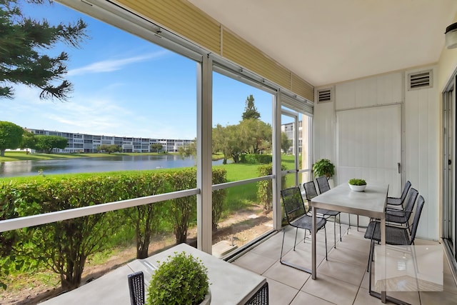 sunroom / solarium featuring a water view