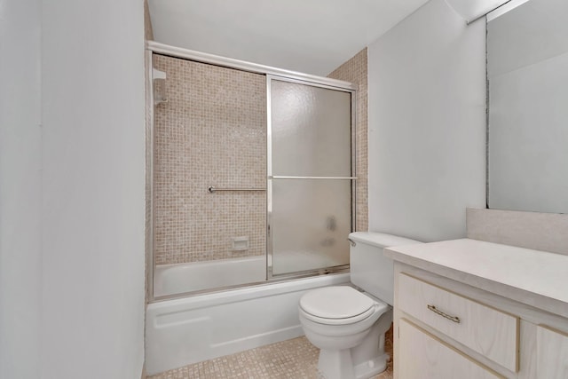 full bathroom featuring toilet, vanity, tile patterned floors, and bath / shower combo with glass door