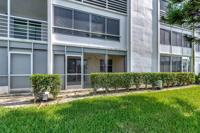 view of exterior entry with a lawn