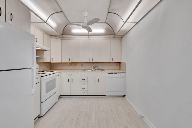 kitchen with white cabinetry, sink, light hardwood / wood-style floors, and white appliances