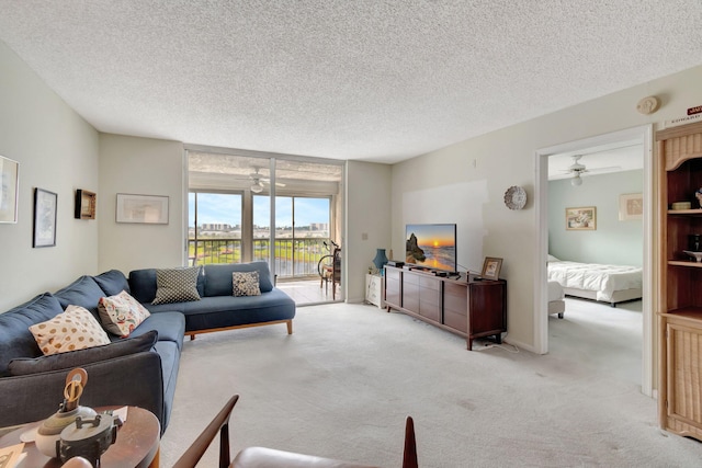 carpeted living room featuring ceiling fan and a textured ceiling