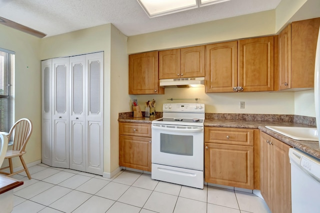 kitchen featuring light tile patterned floors, white appliances, a textured ceiling, and sink