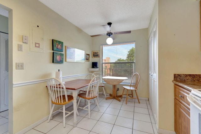 dining space with light tile patterned floors, a textured ceiling, and ceiling fan