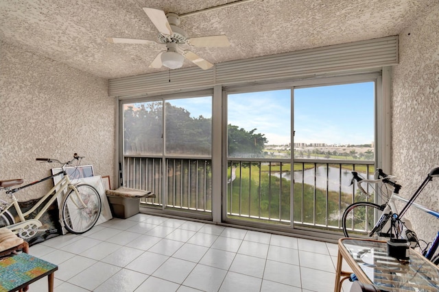 unfurnished sunroom with ceiling fan