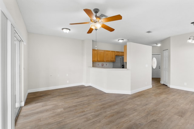 unfurnished living room with ceiling fan and hardwood / wood-style flooring