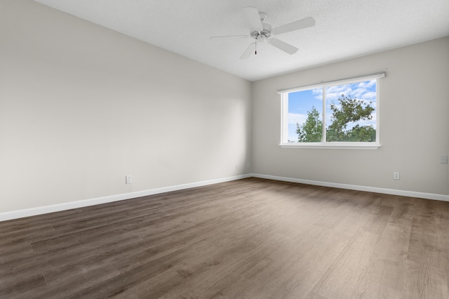 empty room with ceiling fan, a textured ceiling, and dark hardwood / wood-style flooring