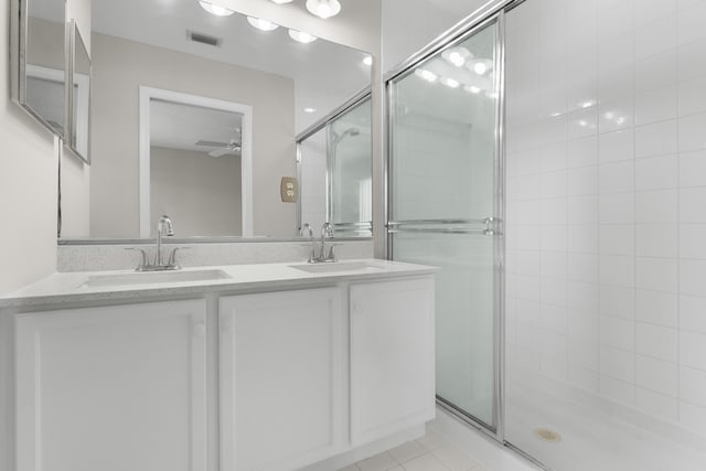 bathroom featuring vanity, ceiling fan, a shower with shower door, and tile patterned flooring