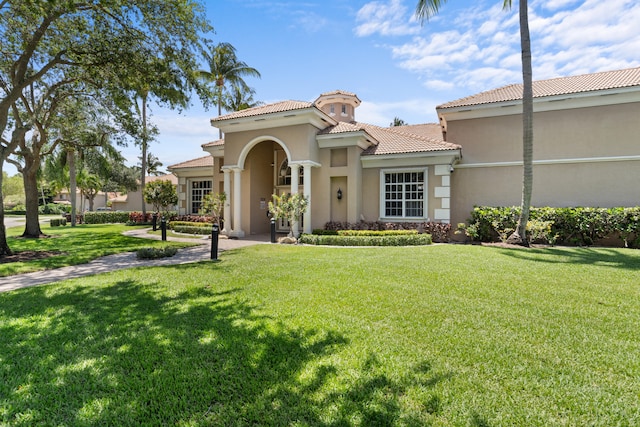 mediterranean / spanish home featuring a front yard