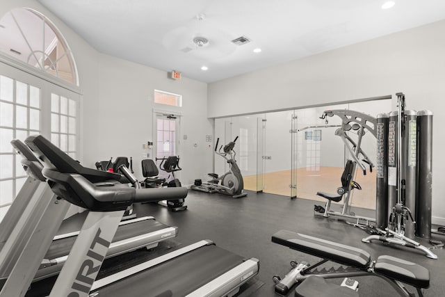 workout area with a towering ceiling and ceiling fan