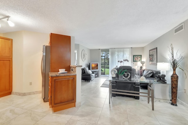 interior space featuring light tile patterned floors and a textured ceiling