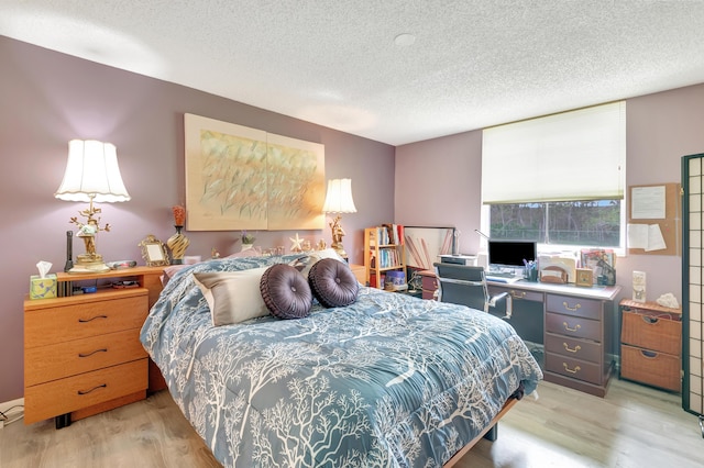 bedroom with a textured ceiling and light hardwood / wood-style floors