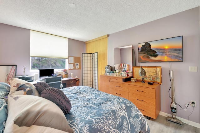 bedroom featuring a textured ceiling and light wood-type flooring