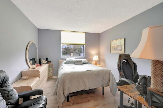 bedroom featuring light wood-type flooring and a textured ceiling