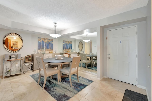 dining space with light tile patterned flooring and a textured ceiling