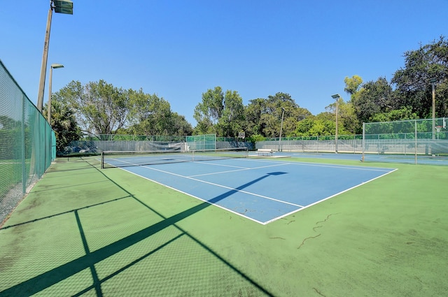 view of tennis court featuring basketball hoop