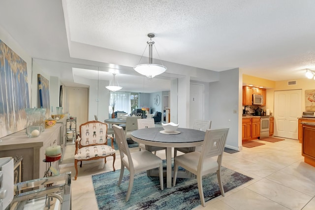 dining room with light tile patterned floors and a textured ceiling