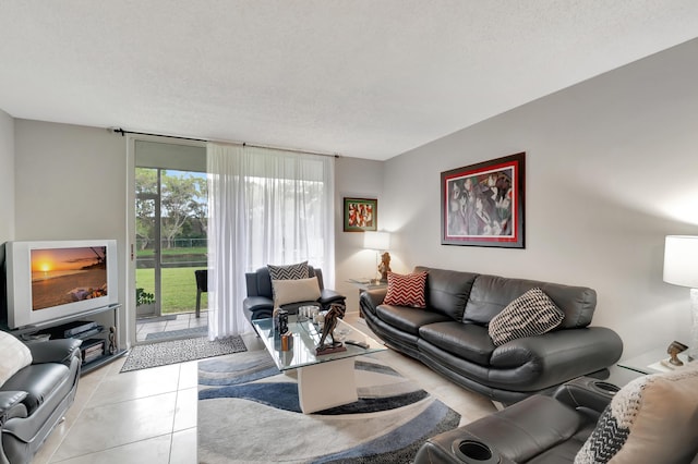 tiled living room featuring a textured ceiling and a wall of windows