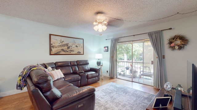 living room featuring a textured ceiling, light hardwood / wood-style floors, and ceiling fan